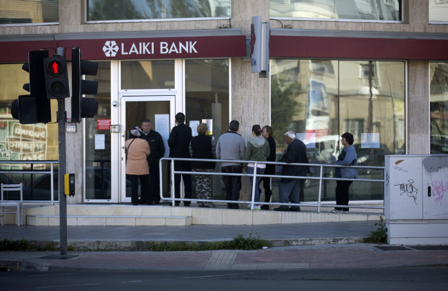 Customers queue outside a branch of Laiki Bank in Nicosia, Cyprus, Friday. (Bloomberg)