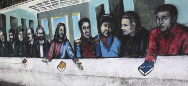 A mural imitating the religious painting the Last Supper covers a wall of a popular housing complex, showing (from left to right) Fidel Castro, Ernesto “Che” Guevara, Mao Tse-tung, Vladimir Lenin, Karl Marx, Jesus Christ, Simon Bolivar, Venezuelan rebel fighters Alexis Gonzalez and Fabricio Ojeda and Venezuela’s late President Hugo Chavez in Caracas on March 5. (AP-Yonhap News)