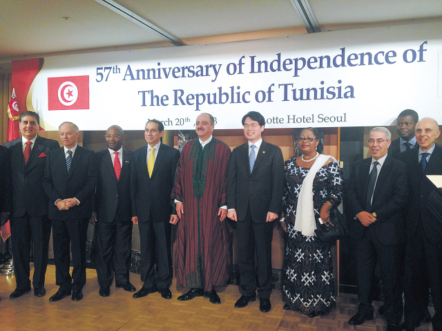 Tunisian Ambassador to Korea Mohamed Ali Nafti (fifth from left) poses for a group photo with a governmentofficial and foreign envoys during a reception celebrating the 57th anniversary of the country’s independence and the second anniversary of the Jasmine Revolution in Seoul on Monday.