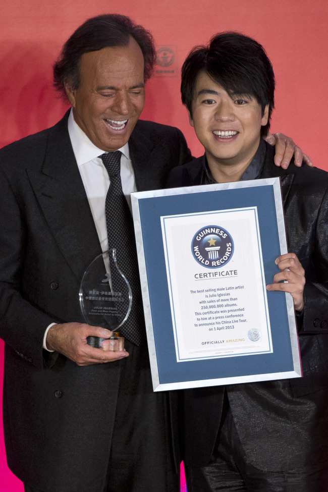 Spanish singer Julio Iglesias (left) and Chinese pianist Lang Lang pose for photos after Iglesias received the Guinness World Record for the best-selling male Latin artist in history and the First & Most Popular International Artist in China Award from Sony Music at a hotel in Beijing, China, on Monday. (AP-Yonhap News)