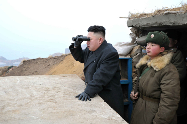 North Korean leader Kim Jong-un uses a pair of binoculars to look at the South’s territory from an observation post at the military unit on Jangjae islet near the border with South Korea in this March 7 file photo released by the Korean Central News Agency. (Yonhap News)