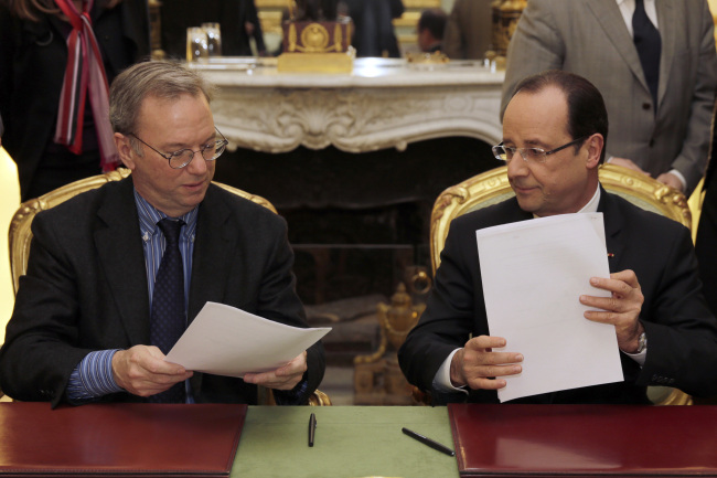 Google CEO Eric Schmidt (left) and French President Francois Hollande sign an agreement at the Elysee Palace in Paris on Feb 1. (AP-Yonhap News)