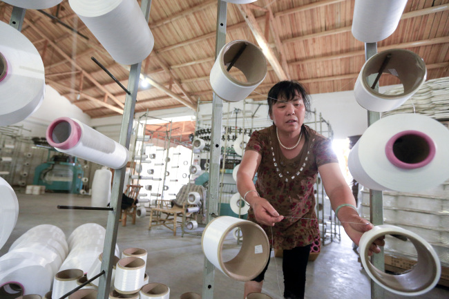 An employee works in a factory producing textiles in Shaoxing, Zhejiang Province, China. (Bloomberg)