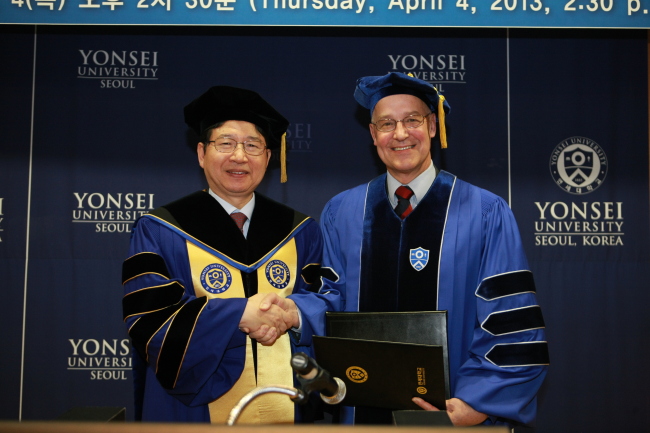 Andrew Hamilton (right), vice-chancellor of the University of Oxford, shakes hands with Yonsei University president Jeong Kap-young after receiving an honorary doctorate degree from the Korean school on Thursday. (Yonsei University)