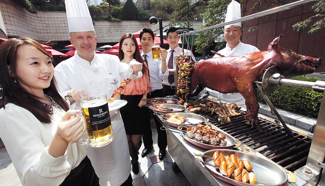 Guests enjoy cold drinks and barbecue at the Renaissance Seoul Hotel on Thursday. The hotel’s outdoor beer garden offers unlimited beer, soju, makgeolli and wine, as well as promotional menus throughout the week. Sausage and meat barbeque are offered on Mondays, Wednesdays and Fridays, while a seafood barbeque buffet is available on Tuesdays and Thursdays through Oct. 31. For more information, call (02) 2222-8630. (Kim Myung-sub/The Korea Herald)