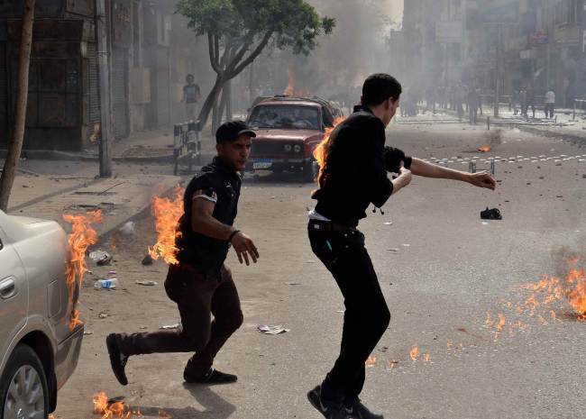 Egyptian Coptic Christians try to put out their burning clothes after they were attacked by unidentified individuals outside the cathedral in the central Cairo neighborhood of Abbassiya on Sunday. (AFP-Yonhap News)