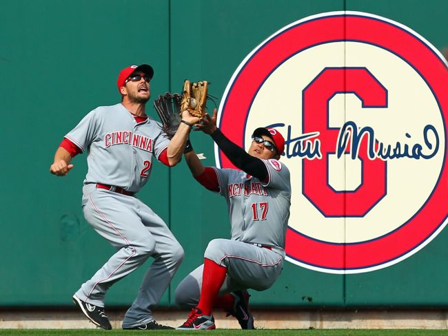 Reds outfielder Chris Heisey makes the catch as he collides with teammate Choo Shin-soo on Monday. (AFP-Yonhap News)