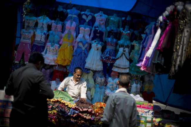 A vendor sets up a clothing stall in the New Market area of Kolkata, India. (Bloomberg)