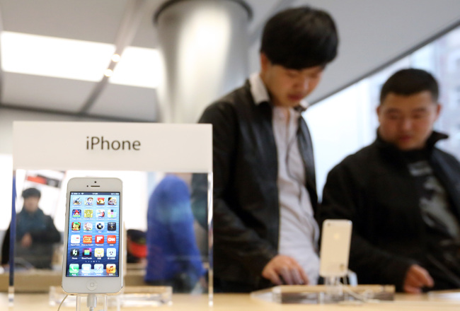 Customers try an Apple Inc. iPhone 5 at the store in the Wangfujing area of Beijing on March 12. (Bloomberg)