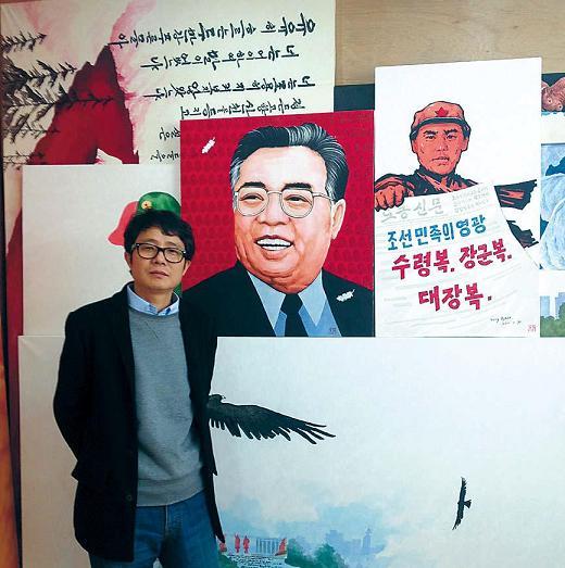 Song Byeok poses for a photo in front of some of his paintings during an interview with The Korea Herald at his studio in southern Seoul on Monday. Song’s exhibition at Conoi gallery in Sinsa-dong runs until April 23. (Philip Iglauer/The Korea Herald)
