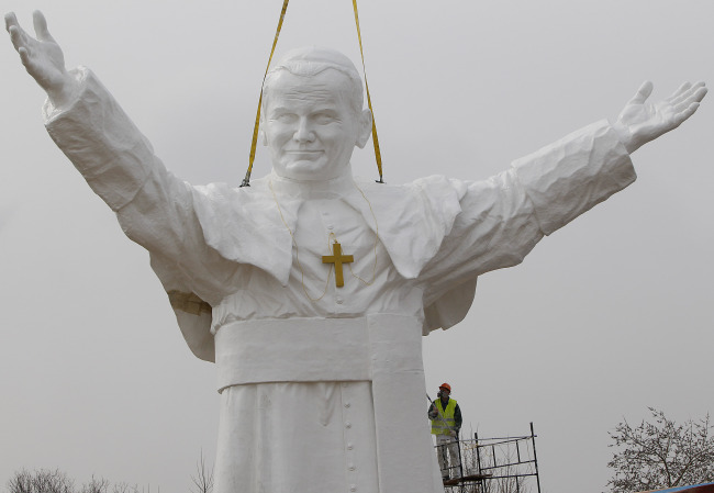 A worker adds finishing touches to a giant statue of the late Pope John Paul II being readied for unveiling this weekend in Czestochowa, Poland, Tuesday. (AP-Yonhap News)