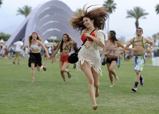 This April 13, 2012 file photo shows festivalgoers running toward the main stage to catch the beginning of Kendrick Lamar’s set during the first weekend of the 2012 Coachella Valley Music and Arts Festival in Indio, California. (AP-Yonhap News)