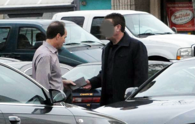 In this undated FBI photo provided by the U.S. attorney’s office, KPMG partner Scott London (left) allegedly accepts a $5,000 cash bribe from Bryan Shaw earlier this year. Federal prosecutors have charged London with providing Shaw with inside information on two California companies, Herbalife Ltd. and Skechers USA Inc. Shaw’s face was obscured by the source of the photo. (AP-Yonhap News)