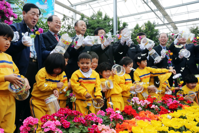 Government officials and children release butterflies on March 20 to celebrate the upcoming butterfly festival in Hampyeong. (Yonhap News)