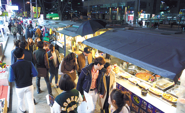 People check out the many street food stalls across the street from Konkuk University’s side entrance.