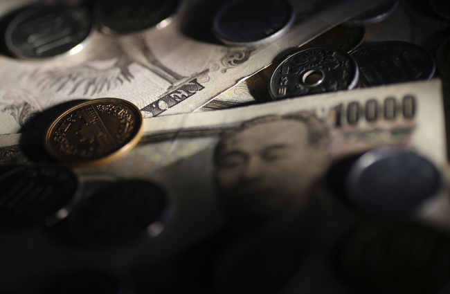 Japanese 10,000 yen banknotes and coins are arranged for a photograph in Tokyo. (Bloomberg)