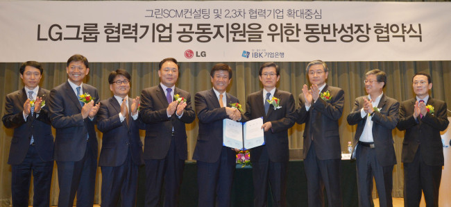 LG Chem president Cho Suk-jeh (fourth from right) shakes hands with IBK CEO Cho Jun-hee after signing an agreement to create funds for shared growth with subcontractors at a ceremony in Seoul on Tuesday. (Kim Myung-sub/The Korea Herald)