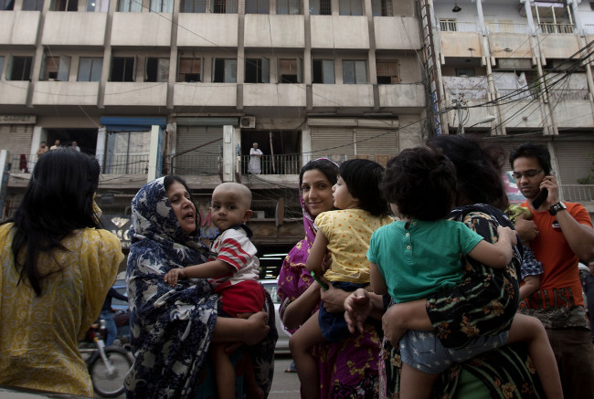 People evacuate buildings and gather on the road as a tremor was felt in Karachi, Pakistan, Tuesday. (AP-Yonhap News)