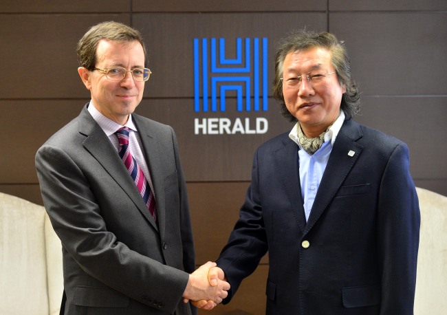 French Ambassador to Korea Jerome Pasquier (left) and Lee Young-man, CEO and publisher of The Korea Herald, shake hands during a courtesy visit by the ambassador to Lee’s office in Seoul on Wednesday. (Lee Sang-sub/The Korea Herald)