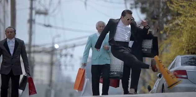 A screen capture of Psy’s “Gentleman” music video scene where he kicks a traffic cone.