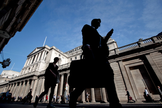 Pedestrians and businessmen pass the Bank of England in London. (Bloomberg)