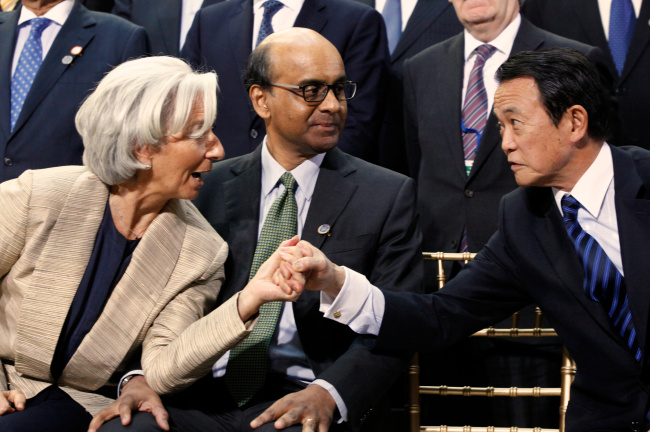 International Monetary Fund Managing Director Christine Lagarde (left) talks with IMF Committee Chair Tharman Shanmugaratnam (center) and Japan’s Minister of Finance Taro Aso before the IMF family photo during the World Bank IMF Spring Meetings in Washington on Saturday. (AP-Yonhap News)