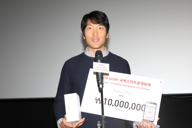 Filmmaker Kim Chan-nyeon receives the top prize at the closing ceremony of the Olleh International Smartphone Film Festival in Seoul on Sunday. (Olleh International Smartphone Film Festival)