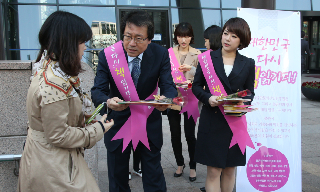 President Lee Jae-ho (center) and staff of the Publication Industry Promotion Agency of Korea give out brochures, roses, and children’s books in Gwanghwamun. (Yonhap News)