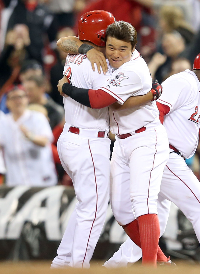 Choo Shin-soo (right) of the Cincinnati Reds celebrates with Cesar Izturis after Izturis hit the game-winning single in the 13th inning to beat the Chicago Cubs at Great American Ball Park in Cincinnati, Ohio, Monday. (AFP-Yonhap News)
