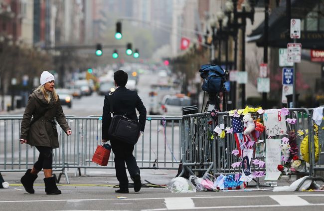 People walk past a barricade and makeshift memorial blocking a still closed section of Boylston Street near the site of the Boston Marathon bombings in Boston, Massachusetts, Tuesday. (AFP-Yonhap News)