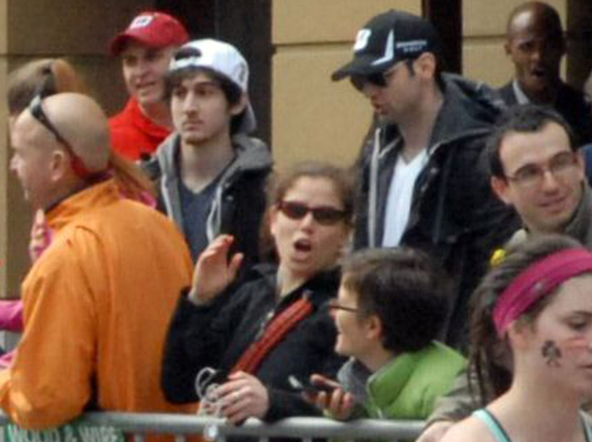 This April 15 photo provided by Bob Leonard shows bombing suspects Tamerlan Tsarnaev (center right in black hat) and his brother, Dzhokhar A. Tsarnaev (center left in white hat), approximately 10-20 minutes before the blasts that struck the Boston Marathon. (AP-Yonhap News)