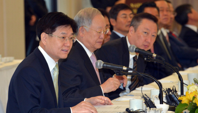 Tax chief Kim Duk-joong (left) speaks at a meeting with a group of entrepreneurs organized by the Korea Chamber of Commerce and Industry in Seoul on Thursday. Next to him are KCCI chairman Sohn Kyung-shik (center) and Doosan Group chairman Park Yong-maan. (Kim Myung-sub/The Korea Herald)