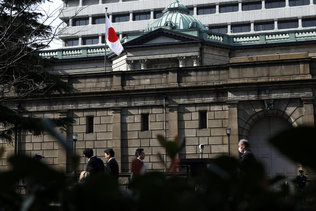 Pedestrians walk past the Bank of Japan headquarters in Tokyo. (Bloomberg)