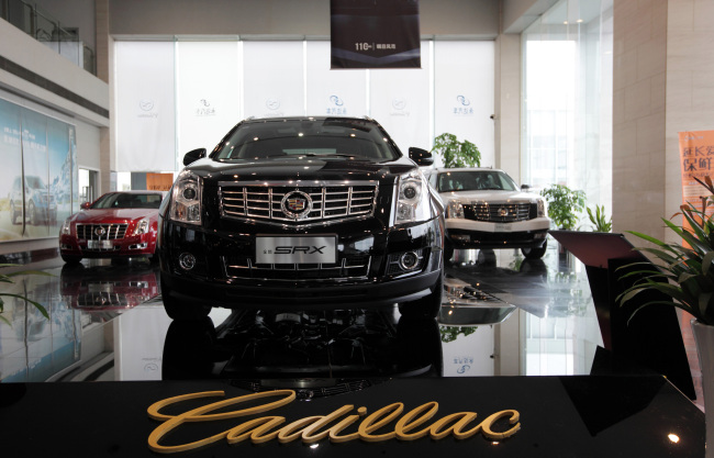 General Motors Co. Cadillac CTS (left), SRX (center) and Escalade Hybrid vehicle are displayed at a dealership in Shanghai. ( Bloomberg)