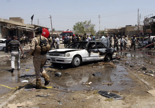 Civilians and security forces gather at the scene of a car bomb attack in the southern Shiite city of Karbala, 80 kilometers south of Baghdad, Monday. (AP-Yonhap News)