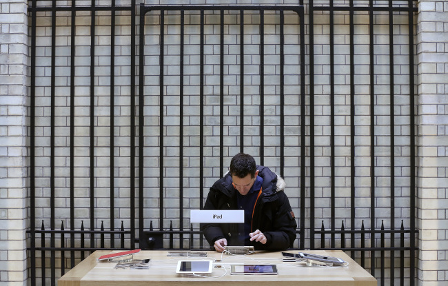 A customer inspects a display model of an Apple Inc. iPad mini at the company’s Covent Garden store in London. (Bloomberg)