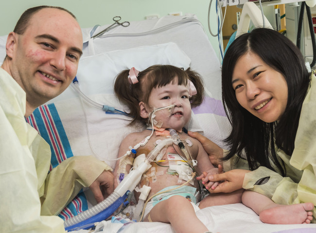 이번에 인공 기관지 이식 수술을 받은 한나 워렌 (2)의 부모인 대럴 워렌 씨와 이영미 씨가 9일 (현지시간) 일리노이 성 프란시스 병원 소아과에서 딸을 간호하고 있다. (AP-연합뉴스)