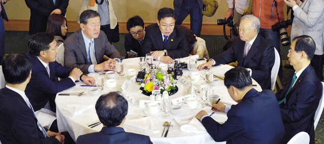 Industry Minister Yoon Sang-jick (center, seated) meets with leaders of the nation’s business associations in Seoul on Thursday. The minister is flanked by FKI chairman Huh Chang-soo (left) and KCCI chairman Sohn Kyung-shik. (Kim Myung-sub/The Korea Herald)