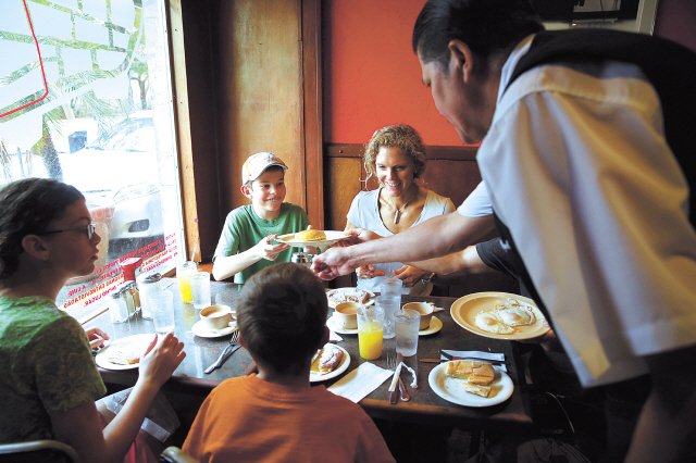 The Althausen family, from Reno, Nevada, prepares for a meal at Cafeteria Mallorca. Cruise ships dock nearby, so the place can get full of tourists. (Chicago Tribune/MCT)