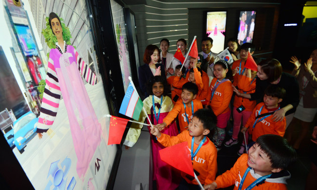 Children from multicultural families try out advanced technology during their visit to SKT’s Ubiquitous Museum at its headquarters on Monday. The company invited them in celebration of Children’s Day, which fell on May 5. (Kim Myung-sub/The Korea Herald)