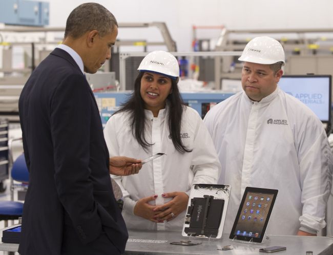 U.S. President Barack Obama holds a smartphone component while speaking with employees at Applied Materials, a manufacturer of systems for polishing the surface of unfinished semiconductor chips, in Austin, Texas, Thursday. (AFP-Yonhap News)