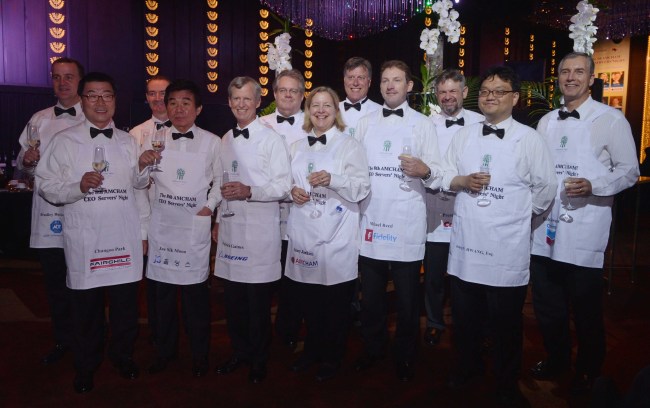 AMCHAM Korea chairman Pat Gaines (third from left, front row) and other chamber members pose during the “8th AMCHAM CEO Servers’ Night,” an annual charity event where business executives dress up as waiters and serve a four-course dinner to their clients, employees and family members, in June last year. (Lee Sang-sub/The Korea Herald)