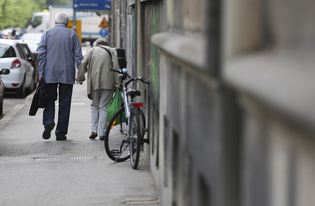 An elderly couple walk along a street in Ljubljana, Slovenia, Friday. (Bloomberg)