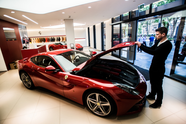 An employee lifts the hood of a Ferrari F12 Berlinetta sports car in the showroom of an automobile dealership in Budapest, Hungary, Wednesday. (Bloomberg)