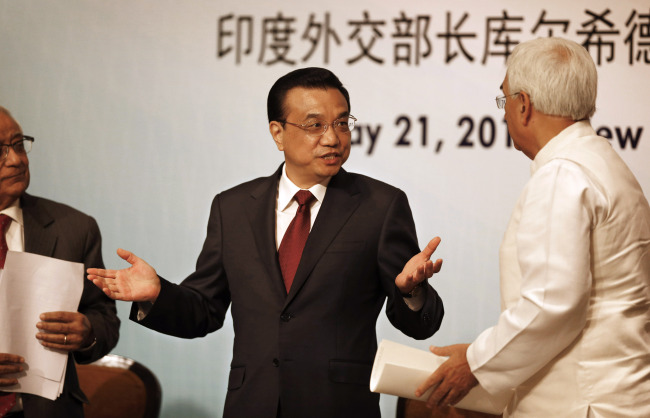 Chinese Premier Li Keqiang (center) gestures as he talks to Indian External Affairs Minister Salman Khurshid (right) at an event organized by Indian Council of World Affairs in New Delhi on Tuesday. (AP-Yonhap News)