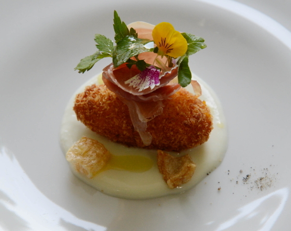 Harmonium’s kabocha squash and mozzarella croquette in Pecorino cheese fondue with fried pork rinds topped with prosciutto. (Chung Hee-cho/The Korea Herald)