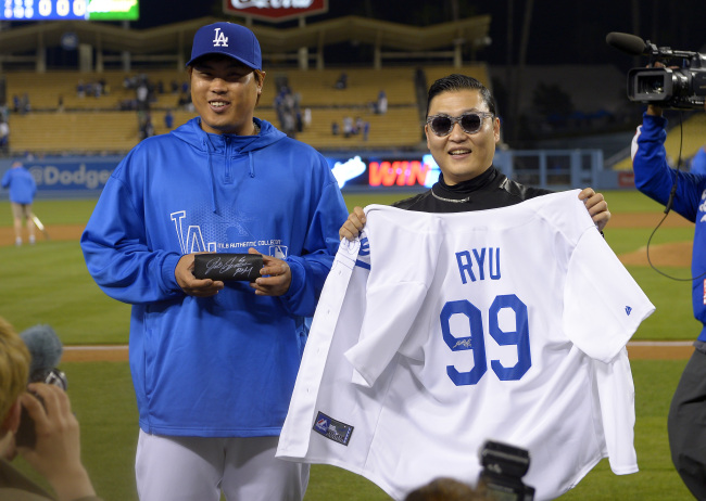 Los Angeles Dodgers starting pitcher Hyun-Jin Ryu, left, of Korea, and Korean pop artist PSY pose together after the Dodgers defeated the Colorado Rockies 6-2 in their baseball game on April 30, 2013, in Los Angeles. (AP-Yonhap News)