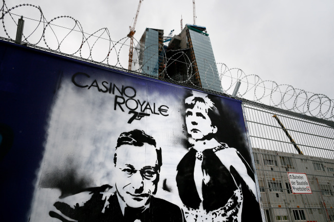 Graffiti depicting ECB president Mario Draghi and German Chancellor Angela Merkel is shown on boards outside the construction site of the European Central Bank’s new headquarters in Frankfurt on Wednesday. (Bloomberg)