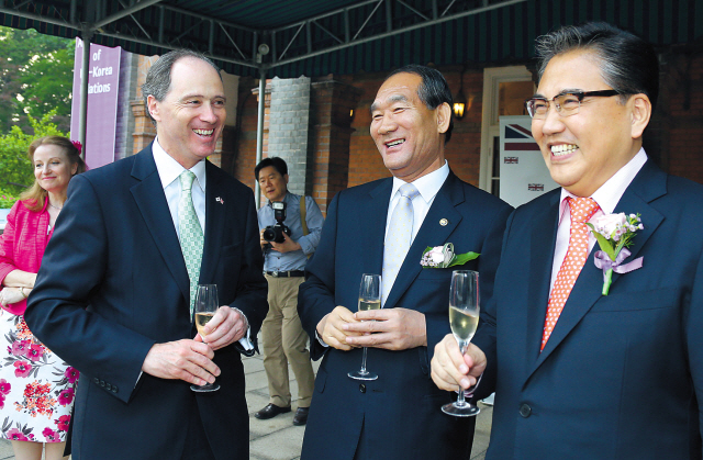 British Ambassador to Korea Scott Wightman (left) enjoys a glass of champagne and a chat with Minister of Patriots and Veterans Affairs Park Sungchoon (center) and former National Assembly representative with the Saenuri Party Park Jin during a celebration of the Queen’s birthday at the ambassador’s residence in Seoul on Thursday. (Yonhap News)