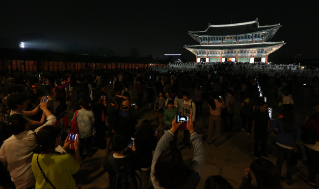 지난 수요일 경복궁 야간개장 첫날 밤 관람객들이 근정전을 배경으로 사진촬영을 하고 있다. (연합뉴스)